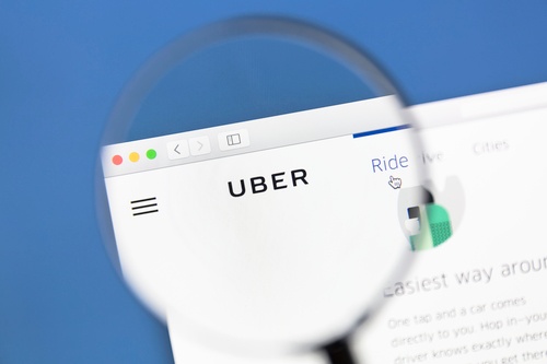 A magnifying glass focusing on Uber logo