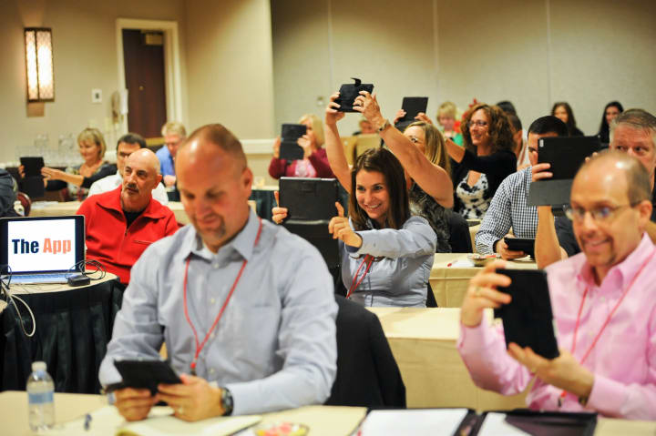 A group of people in a workshop taking a picture of the presentation