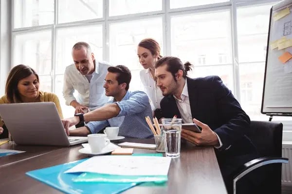 depositphotos_114919690-stock-photo-businessman-explaining-colleagues-with-laptop
