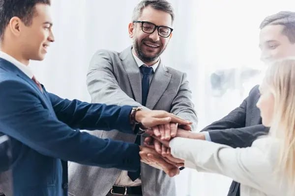 depositphotos_233887740-stock-photo-happy-business-team-stacking-hands