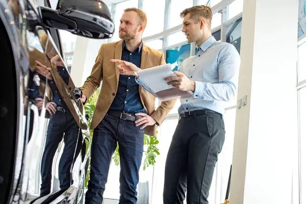 depositphotos_358843648-stock-photo-caucasian-cars-salesman-show-the