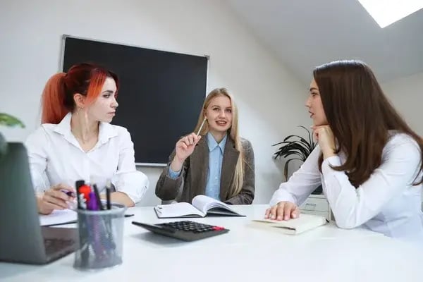 depositphotos_443137608-stock-photo-three-young-women-communicate-workplace