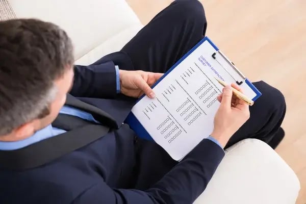 depositphotos_63345177-stock-photo-businessman-filling-customer-survey-form