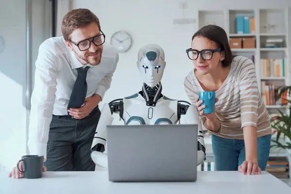 depositphotos_666790410-stock-photo-happy-business-people-supervising-robot